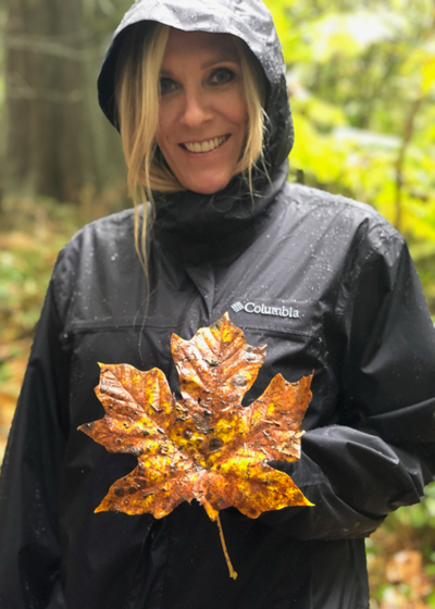 Ellett holds a large leaf on a rainy hike.