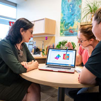 Valeria Molinero works with two students.