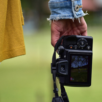 The hand of a white person holding a camera.