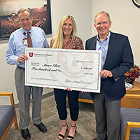 L-R: Chief Technology Officer Jim Livingston, Special Assistant to the CIO Aimee Ellett, and Chief Information Officer Steve Hess pose at 102 Tower with an oversized 