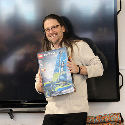 Chief Information Security Officer Corey Roach holds up a catamaran LEGO set during his retirement reception.