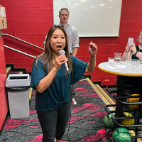 Kim Tanner, foreground, takes the mic to announce the winner of the bowling match.