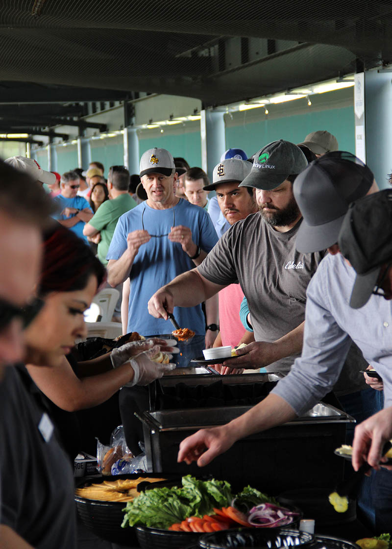 UIT employees fill their plates at the build-your-own burger and hot dog buffet.